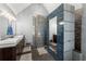 Modern bathroom boasts double sinks, tiled shower with unique design, and elegant lighting at 440 Hunt River Way, Suwanee, GA 30024