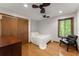 Cozy bedroom with hardwood floors, closet, window views and contemporary chair at 440 Hunt River Way, Suwanee, GA 30024