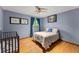 Serene bedroom features hardwood floors, and comfortable bedding near a crib at 440 Hunt River Way, Suwanee, GA 30024