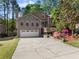 Charming two-story home boasts an attached two-car garage and a well-maintained front yard with mature trees at 440 Hunt River Way, Suwanee, GA 30024