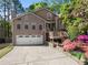 Charming two-story home features a two-car garage, inviting front porch, and beautifully landscaped front yard at 440 Hunt River Way, Suwanee, GA 30024