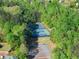 Aerial view of tennis courts surrounded by dense trees and a parking lot at 440 Hunt River Way, Suwanee, GA 30024