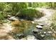 The community's creek features rocks and small falls with lush greenery along the banks at 1318 Crestwind Nw Rd, Kennesaw, GA 30152