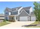 Stunning two-story home with a three-car garage, covered porch, and lush landscaping on a bright, sunny day at 1318 Crestwind Nw Rd, Kennesaw, GA 30152