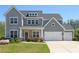Beautifully landscaped two-story home with a charming front porch, a three-car garage, and a well-manicured lawn at 1318 Crestwind Nw Rd, Kennesaw, GA 30152