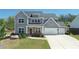 Charming two-story home with a three-car garage, landscaped front yard, and craftsman-style details at 1318 Crestwind Nw Rd, Kennesaw, GA 30152
