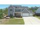 Beautiful two-story home featuring a three-car garage, covered porch, and attractive landscaping in the front yard at 1318 Crestwind Nw Rd, Kennesaw, GA 30152