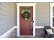 Welcoming front door with decorative wreath, sidelights, and stone accents with a view of a chair at 1318 Crestwind Nw Rd, Kennesaw, GA 30152