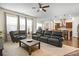 Spacious open-concept living room with leather sofas, a ceiling fan, and seamless access to the kitchen at 1318 Crestwind Nw Rd, Kennesaw, GA 30152