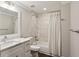 Neutral bathroom with single vanity, framed mirror, and a shower over tub with a curtain at 4505 Glengary Ne Dr, Atlanta, GA 30342