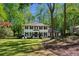 Charming two-story home with a landscaped yard and a classic white facade, surrounded by mature trees at 4505 Glengary Ne Dr, Atlanta, GA 30342