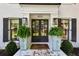 Close-up of the elegant front door with black shutters and decorative plants, framing the entrance at 4505 Glengary Ne Dr, Atlanta, GA 30342