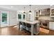 Kitchen with island and seating, stainless steel hood, a view to a deck, and warm wood floors at 4505 Glengary Ne Dr, Atlanta, GA 30342