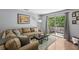 Comfortable living room with a plush sofa, wood floors, and sliding glass doors to the balcony at 5400 Roswell Rd # H5, Atlanta, GA 30342