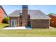 Brick house backyard featuring a chimney and a concrete patio, perfect for outdoor relaxation and entertaining at 8531 Spivey Village Trl, Jonesboro, GA 30236