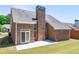 Brick house backyard featuring a chimney and a concrete patio, perfect for outdoor relaxation and entertaining at 8531 Spivey Village Trl, Jonesboro, GA 30236