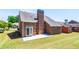 Brick house backyard featuring a chimney and a concrete patio, perfect for outdoor relaxation and entertaining at 8531 Spivey Village Trl, Jonesboro, GA 30236