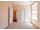 Neutral bedroom with a double closet, natural light from a large window, and an open doorway at 8531 Spivey Village Trl, Jonesboro, GA 30236