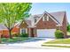 Attractive brick home with a manicured lawn, mature tree, and a two-car garage at 8531 Spivey Village Trl, Jonesboro, GA 30236