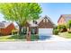 Charming brick home featuring a well-manicured lawn, mature tree, and two-car garage at 8531 Spivey Village Trl, Jonesboro, GA 30236