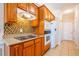 Kitchen with tiled backsplash, wood cabinets and an electric cooktop at 8531 Spivey Village Trl, Jonesboro, GA 30236