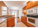 Sunlit kitchen view with stainless steel sink, dishwasher, and oak cabinets at 8531 Spivey Village Trl, Jonesboro, GA 30236