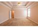 Spacious carpeted main bedroom with a ceiling fan, tray ceilings, and views at 8531 Spivey Village Trl, Jonesboro, GA 30236