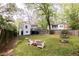 Large backyard with green grass, fire pit, deck, and patio furniture, perfect for outdoor entertaining and relaxation at 308 Greenwood Ave, Decatur, GA 30030