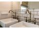 Close up on a double sink vanity with bronze fixtures and square vessel sinks at 308 Greenwood Ave, Decatur, GA 30030