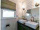 Bathroom featuring double sink vanity, framed mirror, subway tile backsplash, and window with shade at 308 Greenwood Ave, Decatur, GA 30030