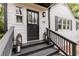 Charming home entrance featuring a black front door, gray stairs, and decorative lanterns at 308 Greenwood Ave, Decatur, GA 30030