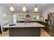 Beautiful kitchen with large granite island, stainless steel appliances, and designer lighting at 308 Greenwood Ave, Decatur, GA 30030