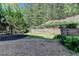 Tranquil backyard featuring a retaining wall, lush landscaping, and natural surroundings at 3330 Camellia Ln, Suwanee, GA 30024
