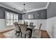 A dining room with gray walls, white wainscoting, hardwood floors, and modern lighting at 3330 Camellia Ln, Suwanee, GA 30024
