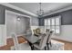 A stylish dining room with gray walls, white wainscoting, hardwood floors, and designer lighting at 3330 Camellia Ln, Suwanee, GA 30024
