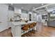 Open kitchen with white cabinets, island seating, stone countertops and stainless steel appliances at 3330 Camellia Ln, Suwanee, GA 30024