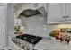 Modern kitchen featuring stainless steel gas range, white cabinets, and stone countertops at 3330 Camellia Ln, Suwanee, GA 30024