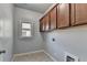 Laundry room features tile flooring, a window and overhead cabinetry at 3330 Camellia Ln, Suwanee, GA 30024