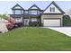 Charming two-story home featuring a well-manicured lawn and a two-car garage at 716 Crimson Morning Vw, Canton, GA 30114