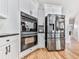 This kitchen features stainless steel appliances, bright white cabinets, and wood-look flooring at 716 Crimson Morning Vw, Canton, GA 30114
