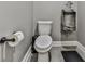 Toilet with toilet paper roll, white toilet, and keg urinal in gray and white bathroom at 716 Crimson Morning Vw, Canton, GA 30114