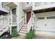 Close-up of a townhome's entrance, featuring stairs leading to a red front door and garage at 1137 Liberty Nw Pkwy, Atlanta, GA 30318