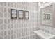 Stylish powder room features patterned wallpaper, modern sink, mirror, and artwork at 2004 Cortland Rd, Milton, GA 30009