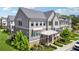 Angle view of an upscale townhome featuring neat landscaping, gray siding, and a silver metal roof at 2004 Cortland Rd, Milton, GA 30009