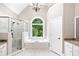 Luxurious bathroom with a soaking tub, glass shower, and marble tile at 226 Crescent Moon Way, Canton, GA 30114