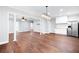 Open-concept living room featuring hardwood floors, stainless steel refrigerator, and elegant light fixtures at 226 Crescent Moon Way, Canton, GA 30114