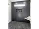 Modern shower with black textured tile, a built-in bench, and a unique pebble floor at 907 Oakhill Sw Ave, Atlanta, GA 30310