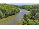 An aerial view showcasing the river running beside the complex, set among lush trees at 1119 Riverbend Club Se Dr, Atlanta, GA 30339