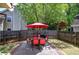 Backyard with patio, grill, lawn, and fenced perimeter surrounded by mature trees at 2186 Mainsail Dr, Marietta, GA 30062