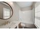 Cozy bathroom featuring shower-tub combo, window, and a round mirror at 22 Haygood Se Ave, Atlanta, GA 30315